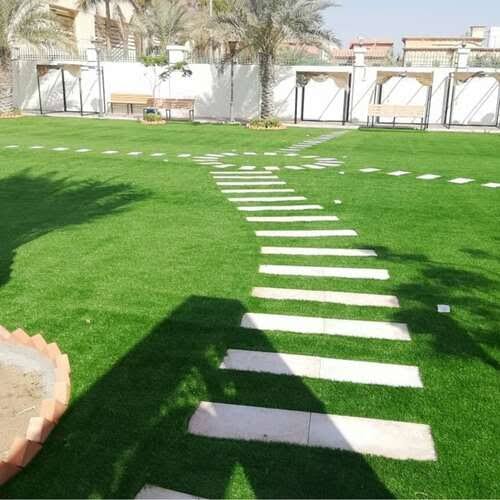 ثيل صناعي مع ممر بلاطات حجرية متعرج داخل حديقة فيلا