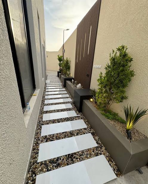 حديقة أمامية بسيطة مع نجيل صناعي ونباتات زينة